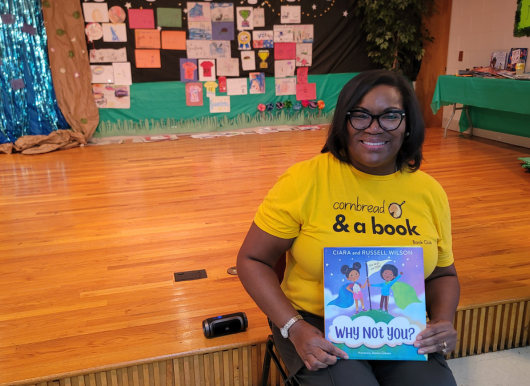 Freedom School guest reader poses with book
